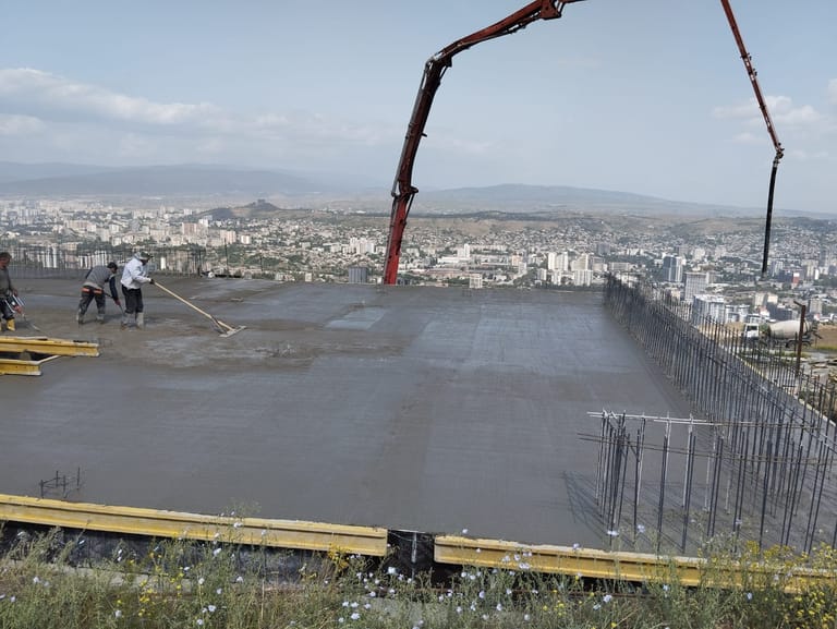 სამშენებლო მოედანზე ბეტონის ტუმბოთი ფილაზე ბეტონის ჩასხმის სამუშაოები